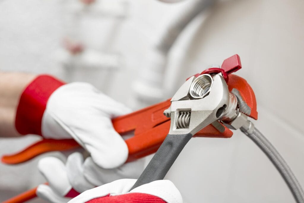 Plumber holding pipe wrenches for an emergency repair in Golden