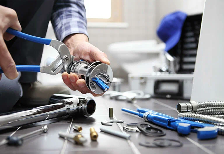 Technician repairing a plumbing fixture with professional tools in Golden