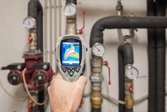 Plumber using a thermal imaging camera to inspect pipes in Golden