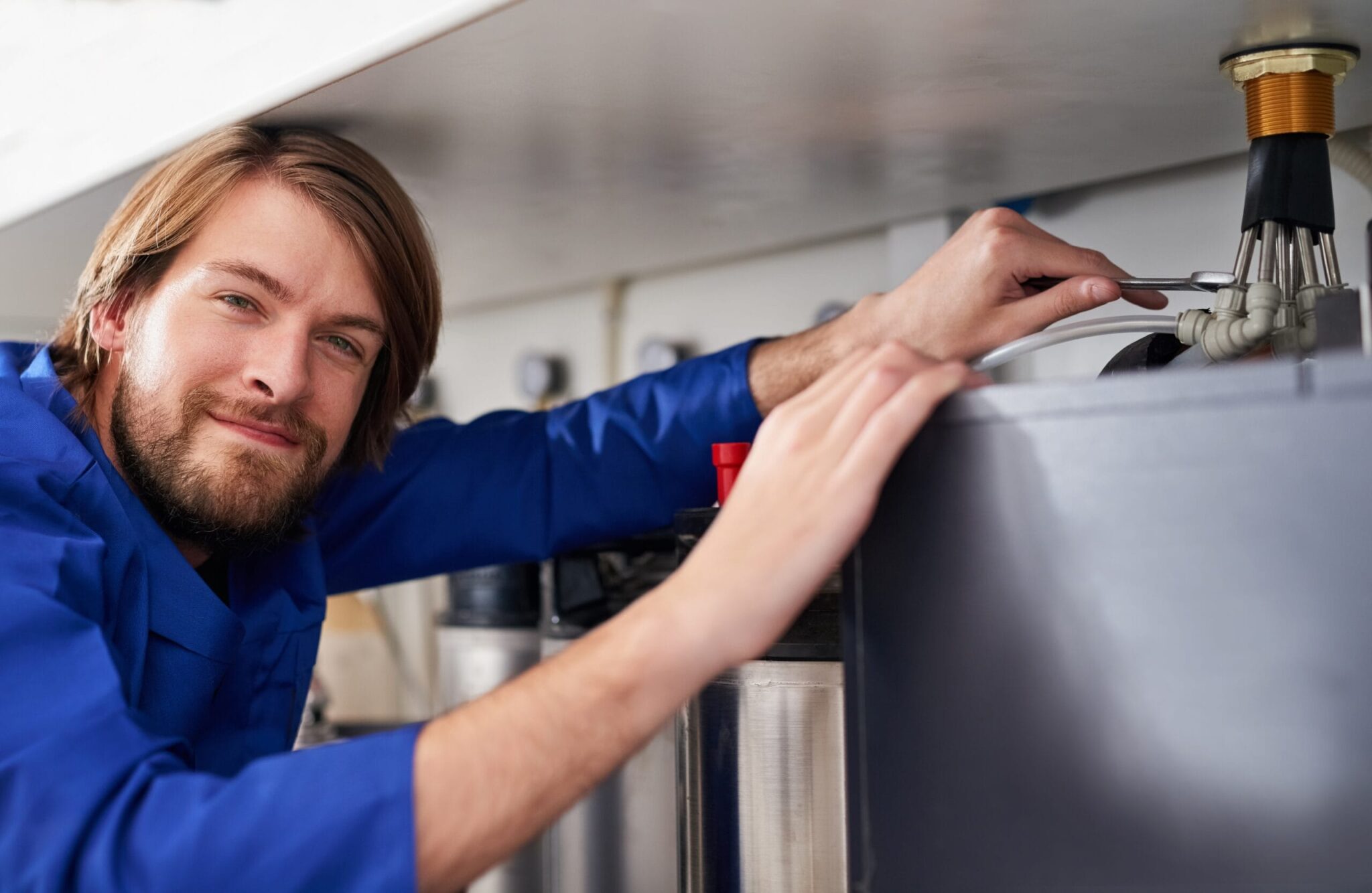 Technician servicing a residential water heater tank in Golden