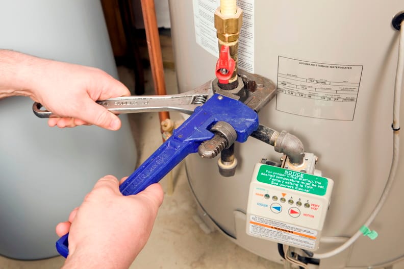 Plumber repairing a water heater valve in Golden